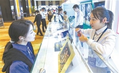 在北京麗澤商務(wù)區(qū)，工作人員（右一）介紹數(shù)字人民幣SIM卡硬錢包。新京報記者 陶冉攝