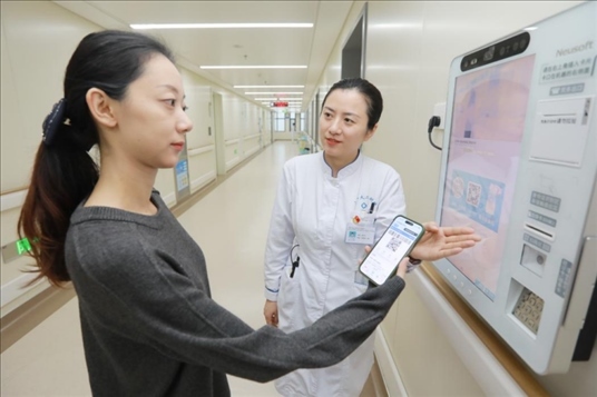 醫(yī)護(hù)人員引導(dǎo)患者在自助機(jī)前辦理自助入院手續(xù)。圖片來(lái)源：山東第一醫(yī)科大學(xué)第二附屬醫(yī)院