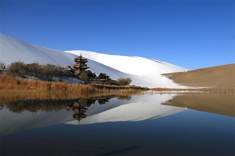 鳴沙山月牙泉景區(qū)雪景。敦煌市委宣傳部供圖，張曉亮攝