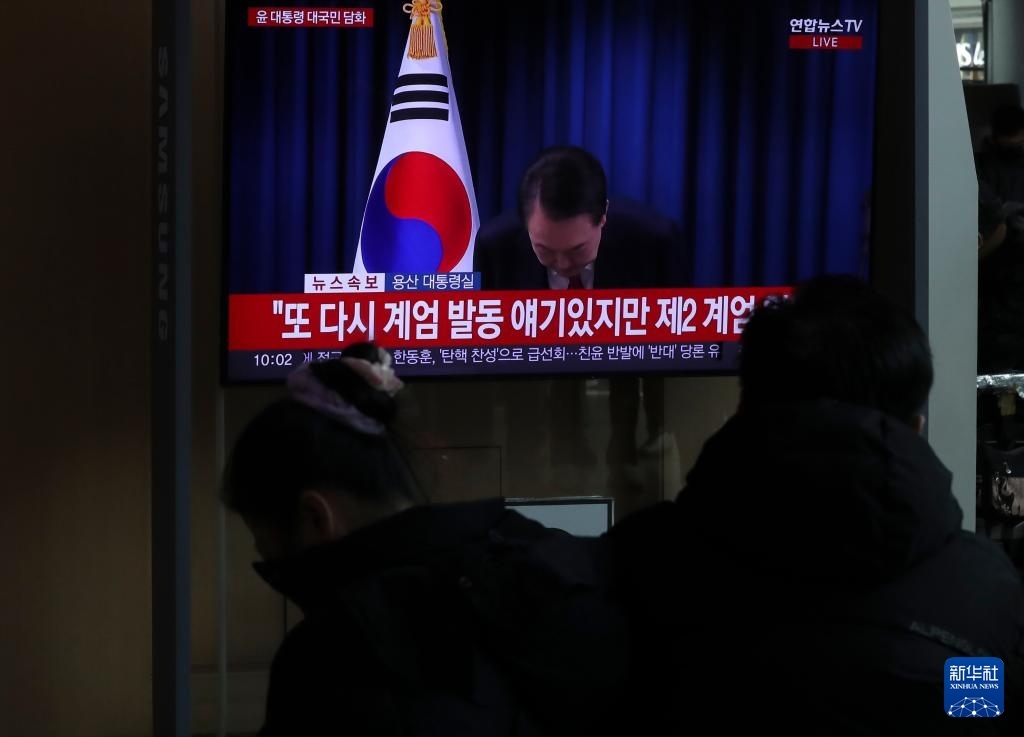 12月7日，在韓國首爾火車站，民眾觀看總統(tǒng)尹錫悅發(fā)表講話的電視畫面。新華社記者 姚琪琳 攝