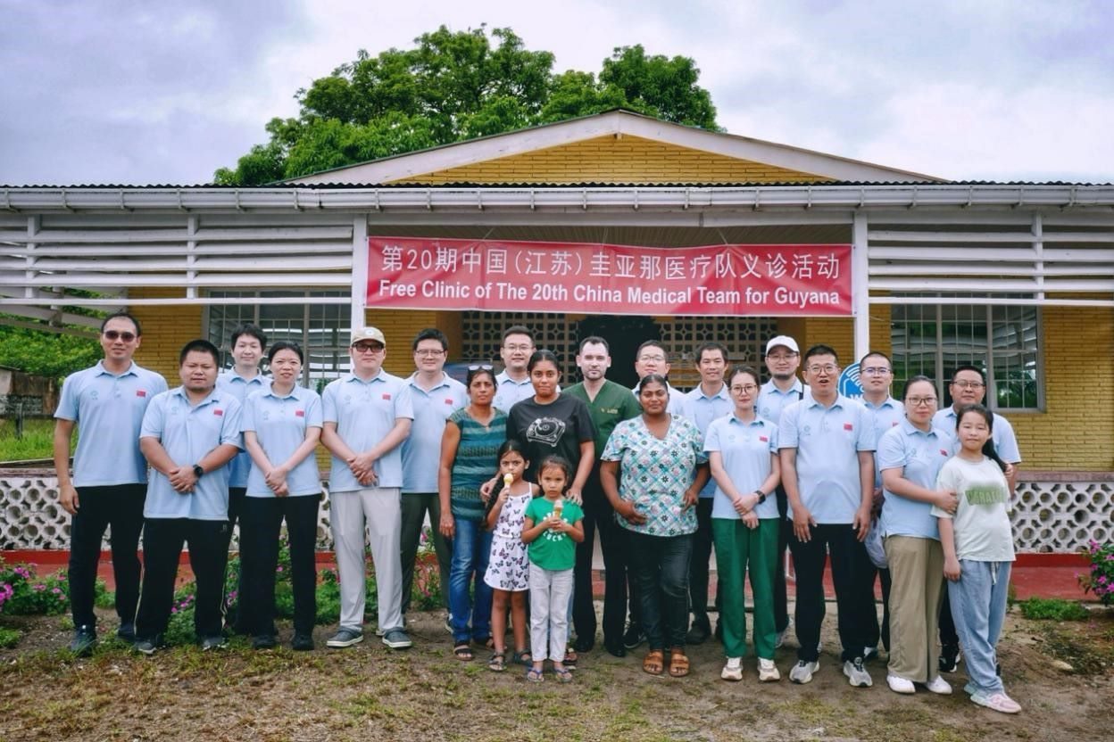 第20期中國（江蘇）援圭亞那醫(yī)療隊在圭偏遠(yuǎn)的林登高速社區(qū)開展義診后，與部分當(dāng)?shù)鼐用窈嫌啊?中國援圭醫(yī)療隊供圖