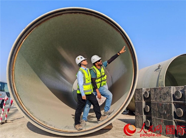 工作人員在察看輸水管情況。人民網(wǎng)記者 管克江攝