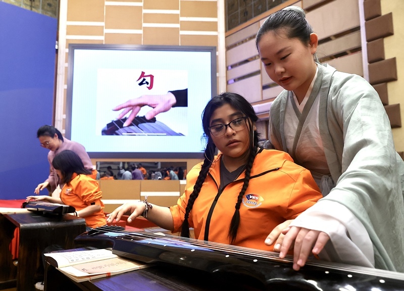 2024年3月20日，美國華盛頓州中學生代表團北京大學交流活動在北京大學英杰交流中心舉行。圖為來自華盛頓州的中學生體驗古琴。