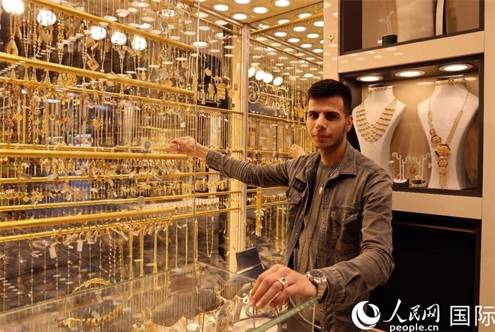 一名銷售員展示黃金飾品。人民網(wǎng) 伊納斯·易卜拉欣攝