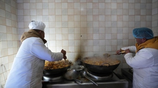 1月14日，服務(wù)隊的兩名廚師正在為村民們做午飯。新華社記者 邱星翔 攝