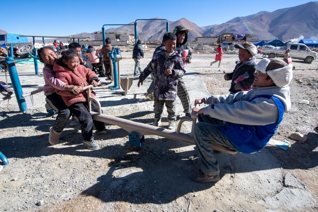 1月11日，在定日縣措果鄉(xiāng)塘仁村安置點(diǎn)，西藏星光社會(huì)工作服務(wù)中心志愿者和孩子們一起玩耍，進(jìn)行災(zāi)后心理疏導(dǎo)。人民網(wǎng)記者 翁奇羽攝