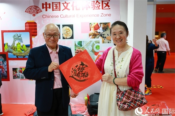 本地觀眾在中國文化體驗區(qū)展示書法作品。人民網(wǎng)記者 白元琪攝