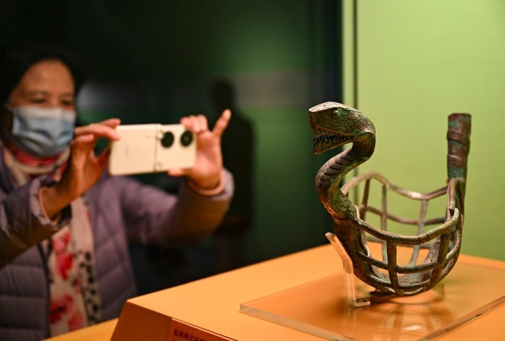 1月14日，觀眾在上海博物館蛇年迎春展拍攝展品蛇綱網(wǎng)狀銅器。新華社發(fā)（陳浩明攝）
