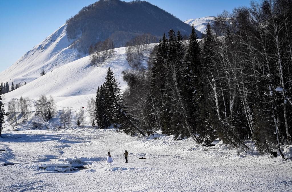 2024年2月5日，兩名游客在新疆阿勒泰地區(qū)布爾津縣禾木村拍照。新華社記者 馬鍇 攝
