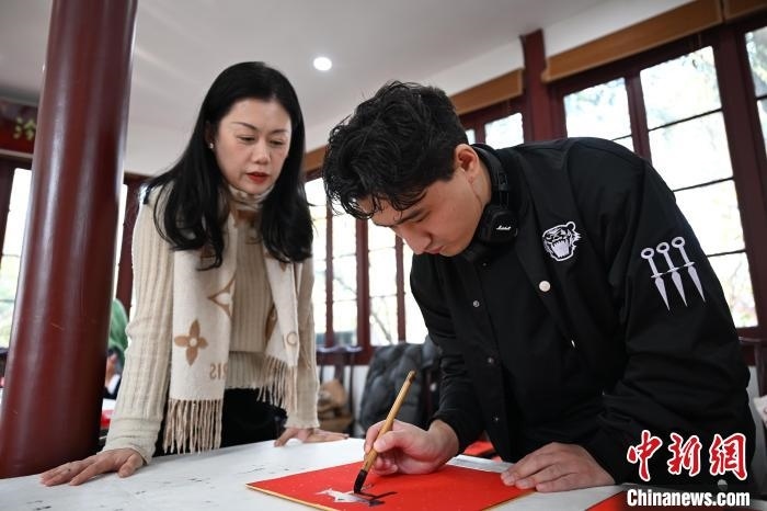 1月20日，外籍留學(xué)生在西泠印社社員李硯指導(dǎo)下寫福。當日，來自巴西、馬來西亞、加納、哈薩克斯坦的外籍留學(xué)生在浙江杭州西泠印社體驗福貼、春聯(lián)和篆刻，感受古老的中國傳統(tǒng)文化。中新社記者 王剛 攝