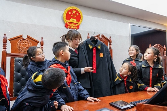 圖②：干警向同學(xué)們介紹法袍。