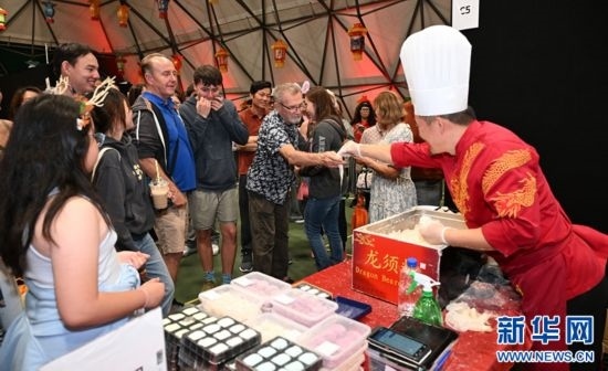 圖為游客在燈節(jié)現(xiàn)場(chǎng)購買小吃。（圖片由奧克蘭中國文化中心提供）