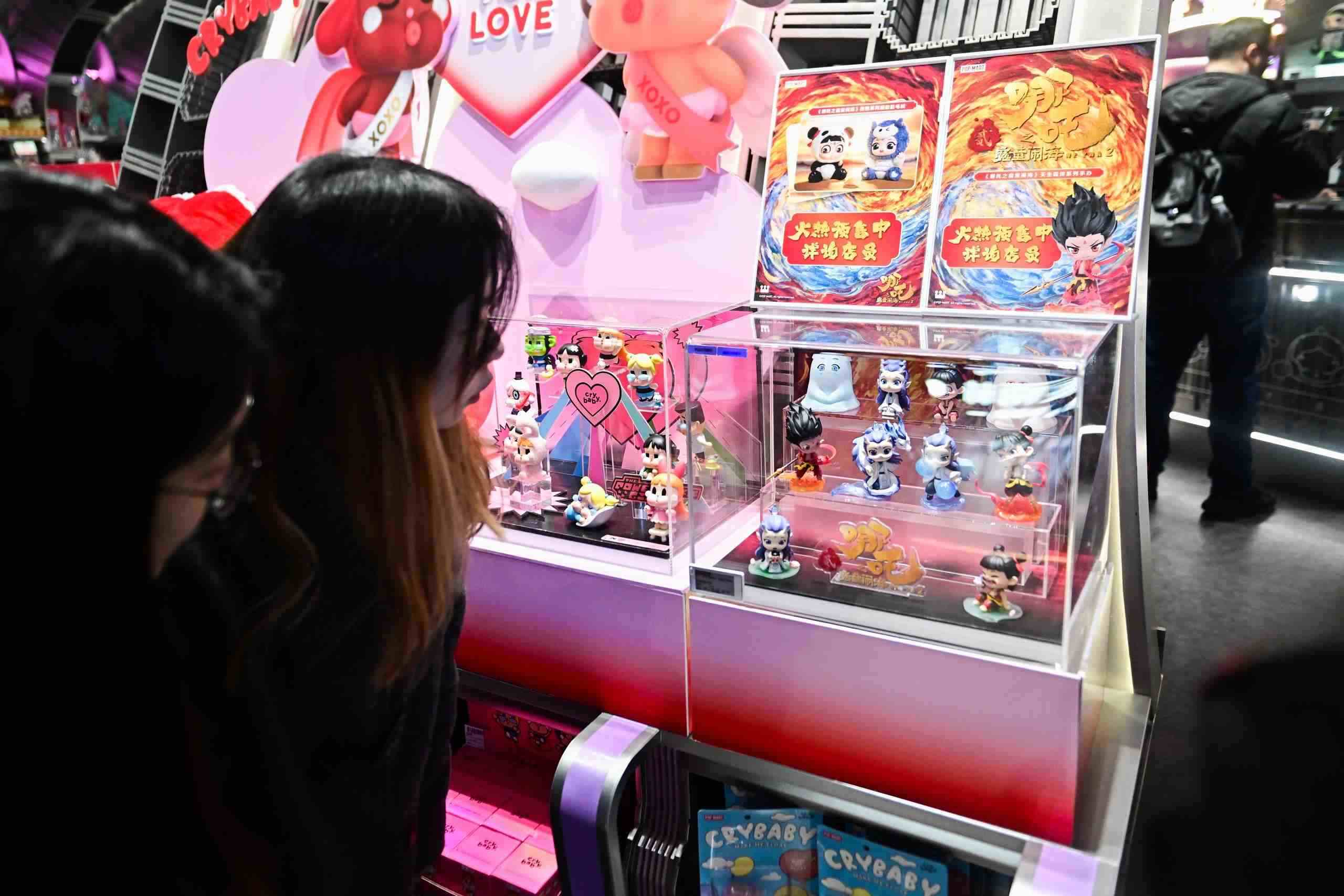 △2025年2月22日，上海，市民在圍觀《哪吒之魔童鬧?！废嚓P(guān)手辦盲盒。