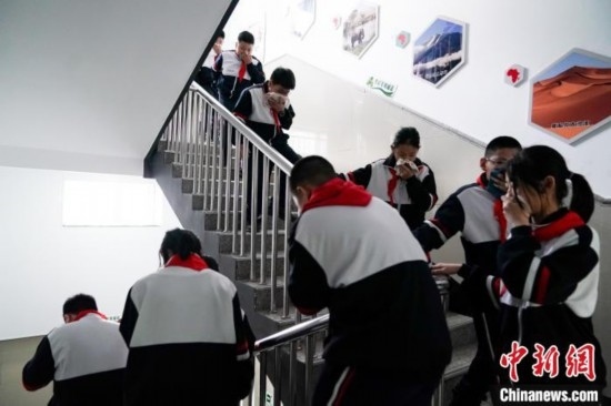  圖為學(xué)生們進(jìn)行應(yīng)急疏散演練。中新社記者 趙宇航 攝