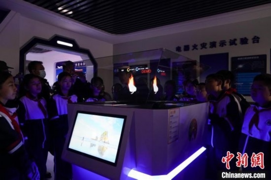 圖為學(xué)生們參觀道里區(qū)消防救援大隊消防科普體驗館內(nèi)幻影成像燃燒三要素實驗臺。中新社記者 趙宇航 攝