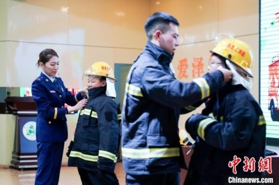 圖為學(xué)生們現(xiàn)場穿戴消防頭盔和戰(zhàn)斗服。中新社記者 趙宇航 攝