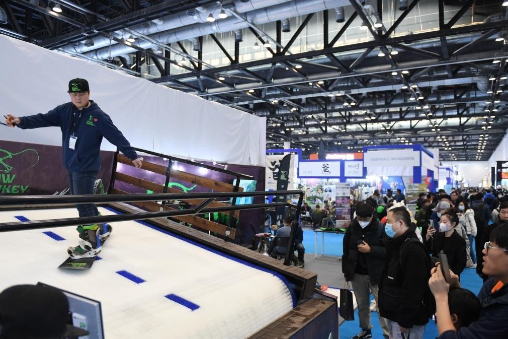 2023年2月11日，參觀者在展會上了解一款模擬滑雪設(shè)備。當(dāng)日，2023亞洲運(yùn)動用品與時尚展在國家會議中心拉開帷幕。新華社記者 張晨霖 攝