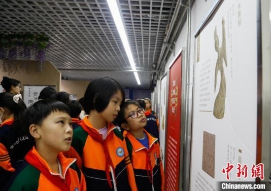 圖為學生參觀青海省博物館“1+3”主題流動展覽，了解木舞俑。中新社記者 馬銘言 攝