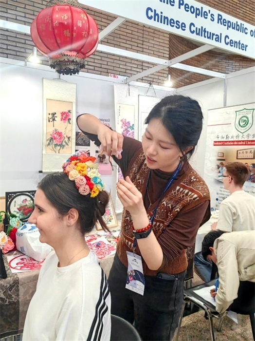 展覽正值羅馬尼亞迎春花節(jié)，國際中文教師志愿者潘婧穎向游客們介紹了國家非物質(zhì)文化遺產(chǎn)——福建泉州的簪花文化。布加勒斯特大學(xué)孔子學(xué)院供圖。