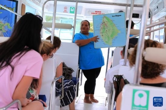 3月15日，一名導(dǎo)游在游艇上為游客介紹塞舌爾拉迪格島。新華社記者 董江輝 攝