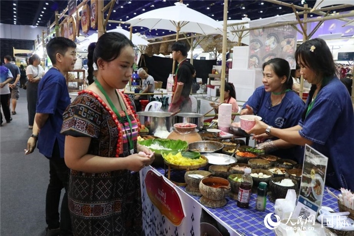 游客在攤位前購買特色美食。朱瀟逸攝