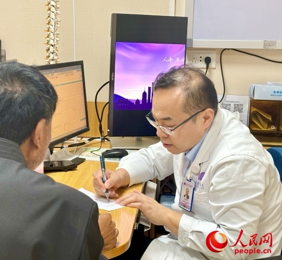 路桂軍接診時為患者寫下用藥提示。人民網(wǎng)記者 金慧慧攝