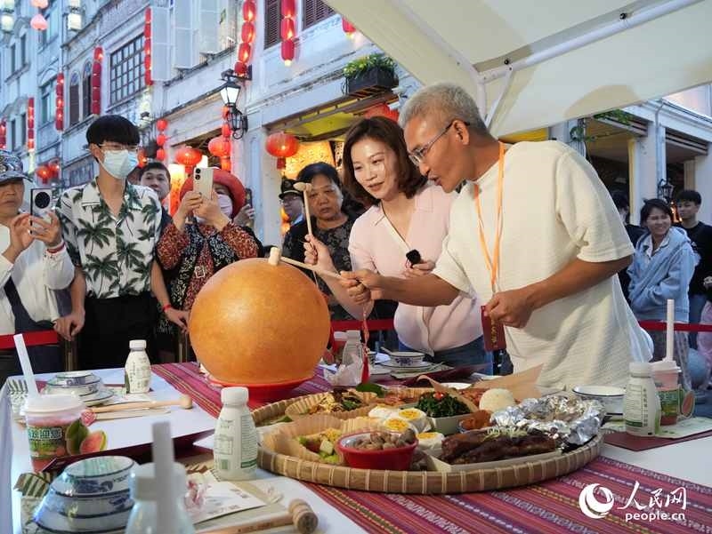 嘉賓品嘗海南傳統(tǒng)美食“煎堆”。人民網(wǎng)記者 張力洋攝