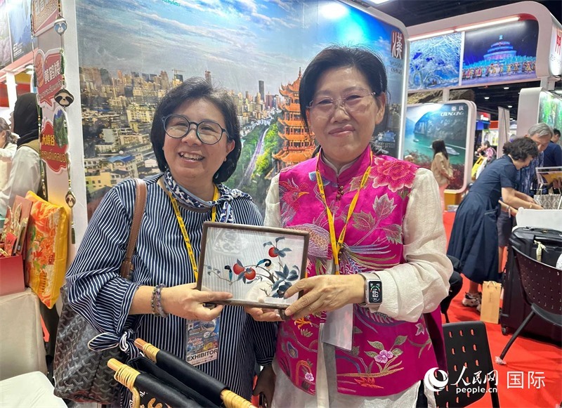 中國(guó)“大冶刺繡”傳承人劉小紅（右）參加泰國(guó)國(guó)際旅游展，向觀眾介紹中國(guó)非遺刺繡針?lè)āＨ嗣窬W(wǎng)記者 簡(jiǎn)承淵攝