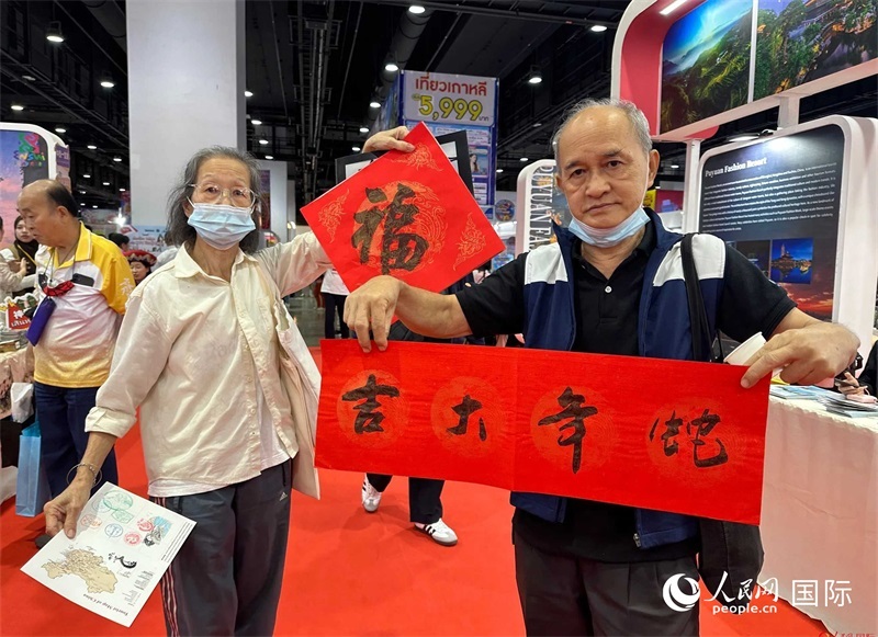 2025蛇年春節(jié)，泰國(guó)市民展示他們領(lǐng)到的華人手寫(xiě)春聯(lián)。人民網(wǎng)記者 簡(jiǎn)承淵攝