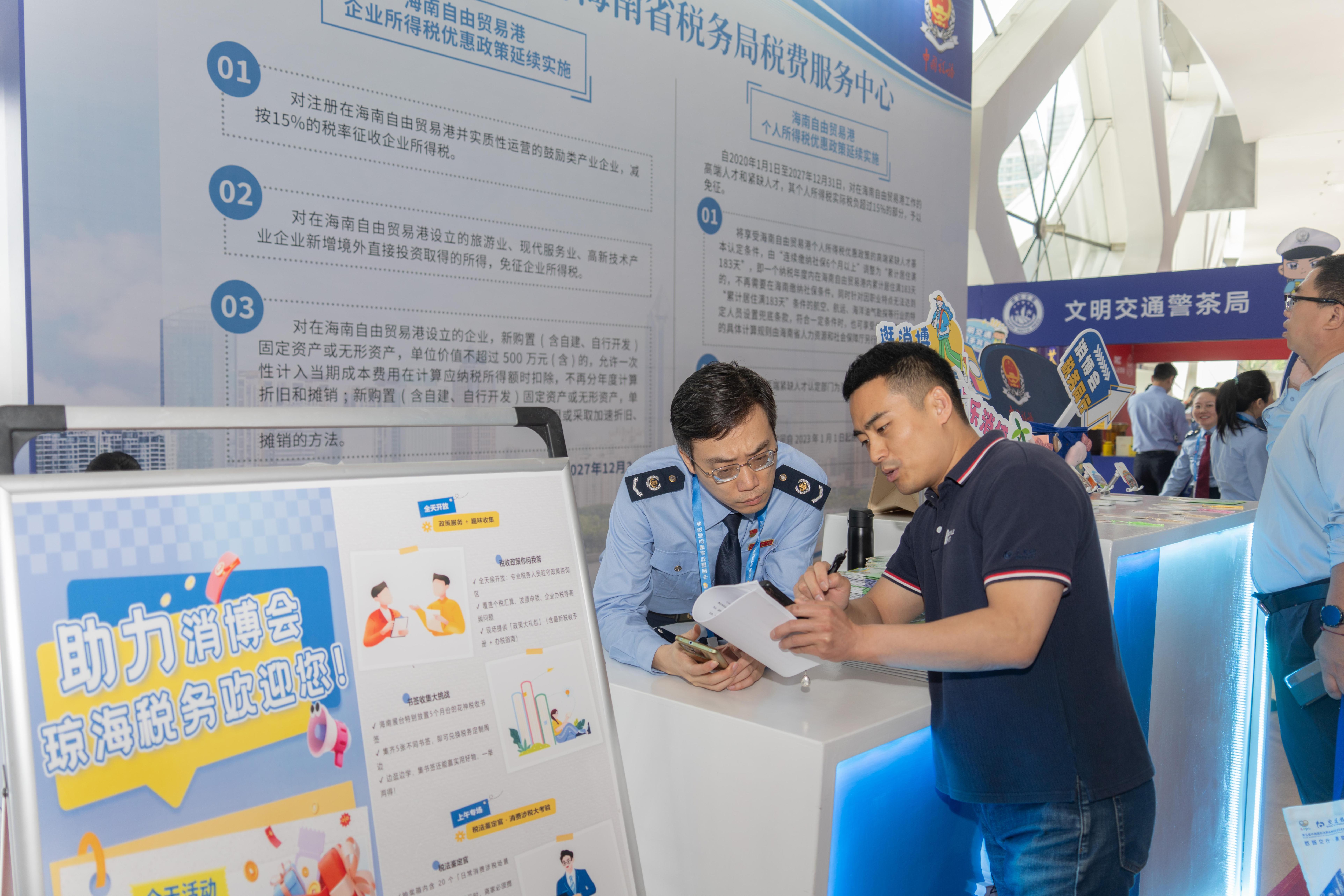 稅務服務臺工作人員向記者介紹服務參展外商的具體舉措。人民網(wǎng)記者 許崢攝