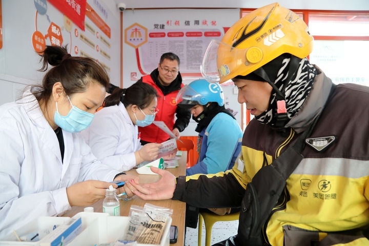 2025年3月5日，志愿者在山東省棗莊市市中區(qū)一工會驛站為外賣員免費測量血糖。新華社發(fā)（王海楠攝）