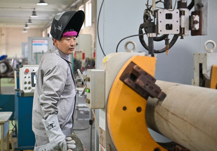 在中石化第四建設有限公司工匠學院，全國人大代表、中石化第四建設有限公司工匠學院焊接教練張振連操作自動焊機（2025年2月21日攝）。新華社記者 孫凡越 攝