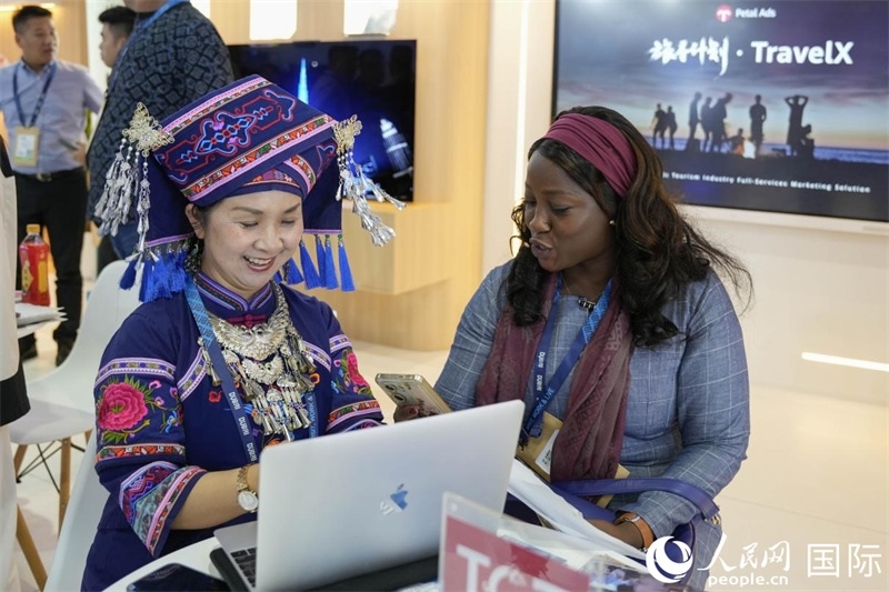 來自廣西的旅游業(yè)者同客戶交流。人民網塔里克·易卜拉欣攝