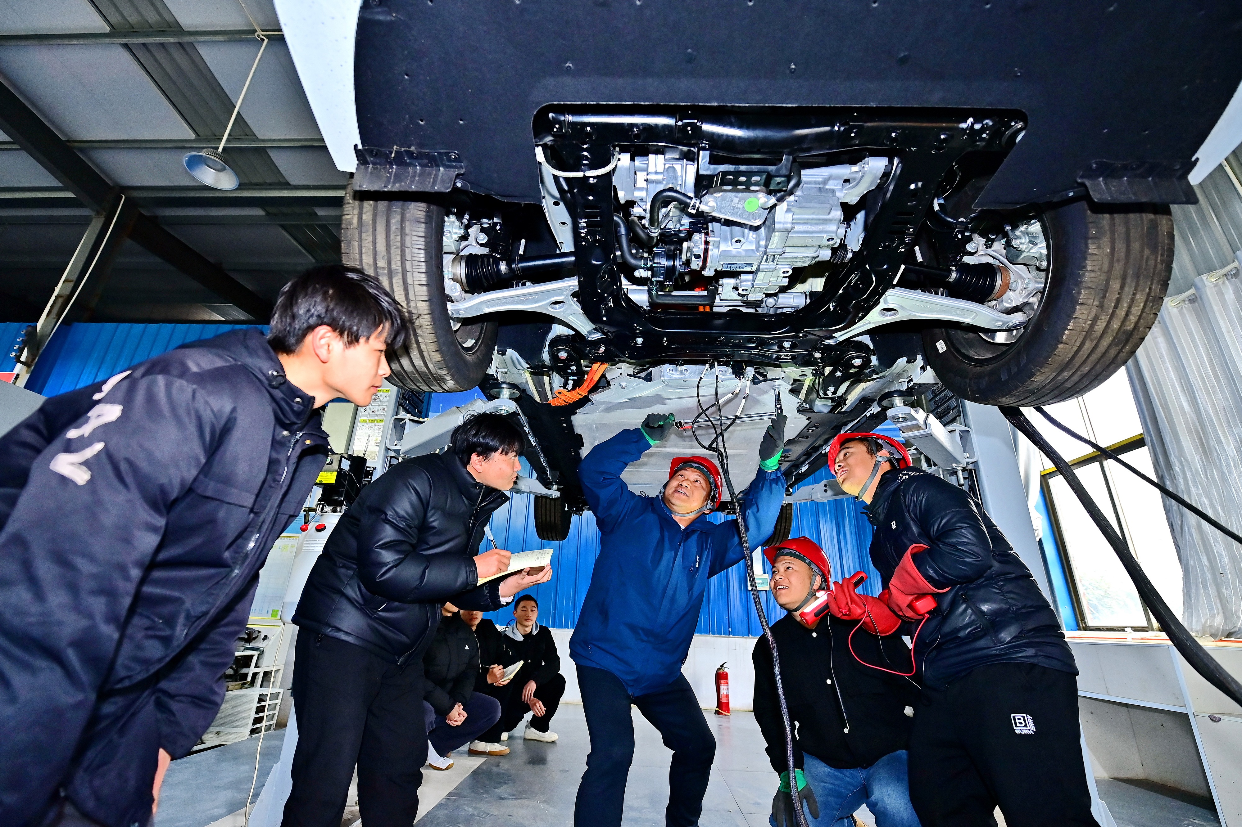 2025年2月，江西省宜春市，豐城市的一所技工學(xué)校實(shí)訓(xùn)基地內(nèi)，新能源汽車運(yùn)維專業(yè)學(xué)生在老師的指導(dǎo)下學(xué)習(xí)新能源汽車電池包檢修技術(shù)。