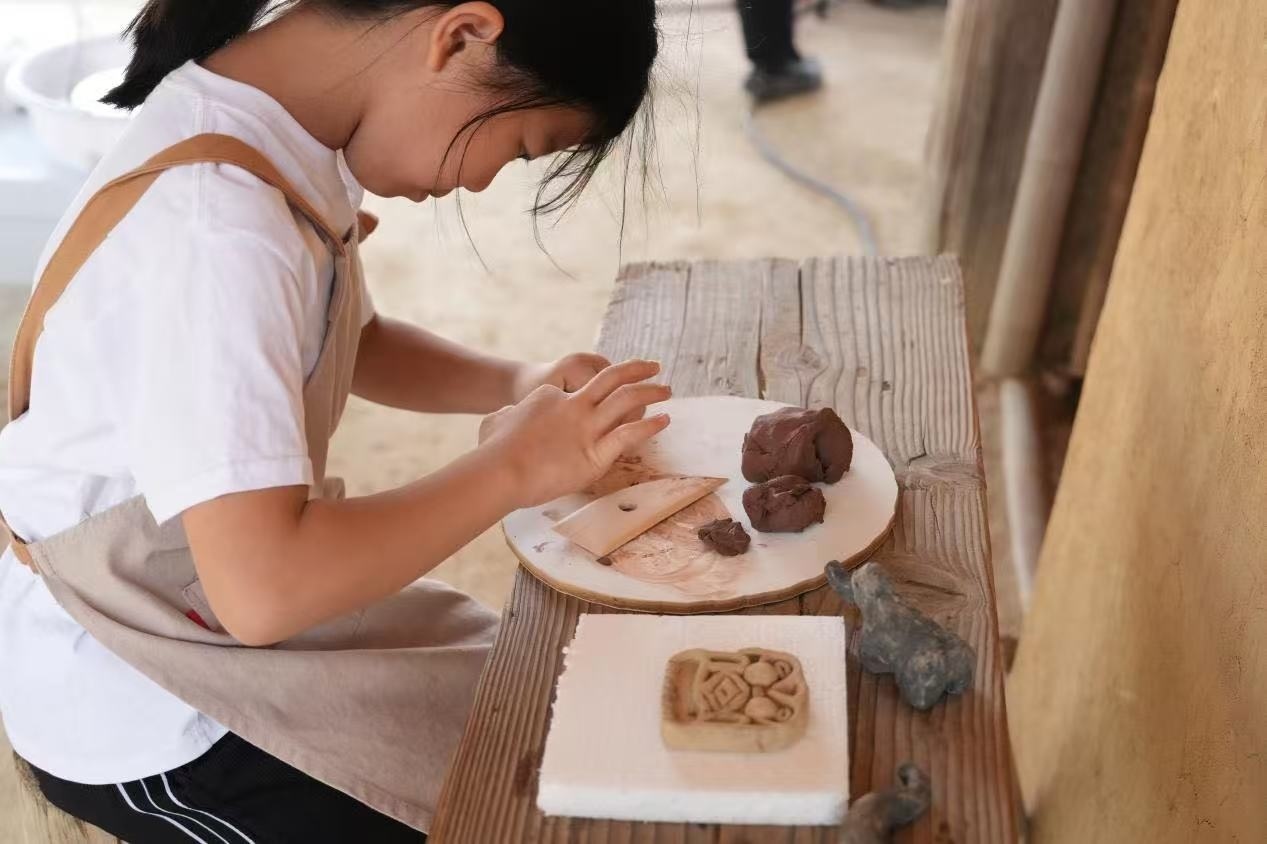 游客制作良渚特色陶藝品。良渚博物院供圖