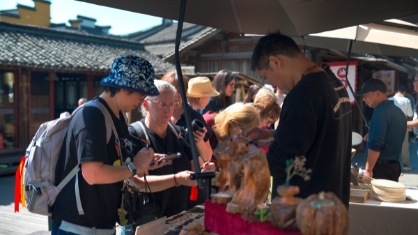 “五一”期間，游客正在烏鎮(zhèn)“水鄉(xiāng)碼頭”挑選購(gòu)買(mǎi)文創(chuàng)產(chǎn)品。受訪者供圖