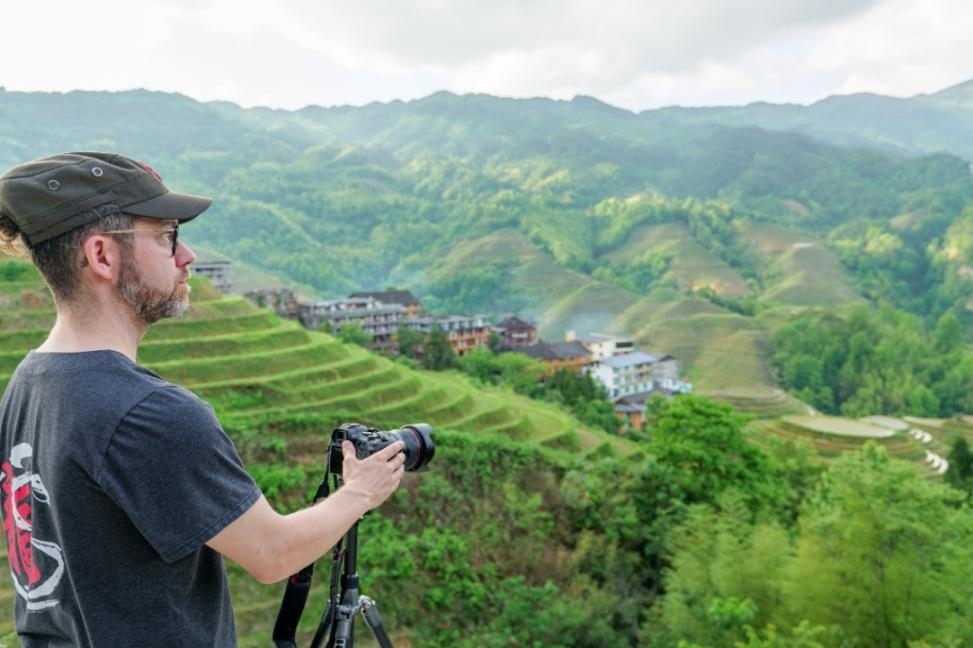 2025年年5月9日，廣西桂林，外國游客游覽龍脊梯田，在美景前駐足拍照。（圖片來源：視覺中國）