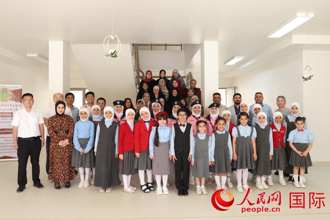 中國(guó)電建員工與阿爾穆塔?阿里卡特國(guó)際學(xué)校的師生及政府官員等合影。人民網(wǎng)記者 薛丹攝