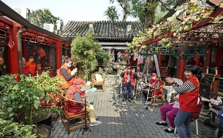 2024年10月12日，鐘樓灣胡同的老年人在社區(qū)內(nèi)的四合院養(yǎng)老驛站休閑。2017年起，北京市先后開展了兩輪背街小巷環(huán)境整治提升行動，完整保留了中軸線生活建筑群的歷史信息，并根據(jù)居民的生活和居住方式進行適配化的更新和改造，極大地改善了生活環(huán)境。2023年鐘樓灣胡同被評為“北京最美街巷”。