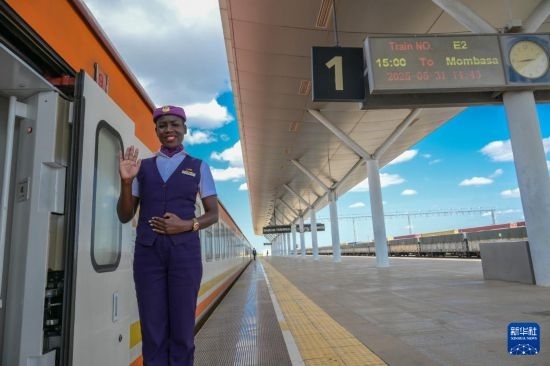 5月31日，在蒙內(nèi)鐵路內(nèi)羅畢站，一名乘務員在即將開往蒙巴薩的E2次列車旁等候乘客。新華社記者 楊光 攝