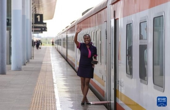 5月31日，在蒙內(nèi)鐵路內(nèi)羅畢站，一名乘務員在即將開往蒙巴薩的E2次列車旁等候乘客。新華社記者 李亞輝 攝