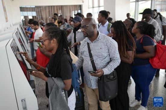 5月31日，在蒙內(nèi)鐵路內(nèi)羅畢站，乘客在自助取票機前排隊取票。新華社記者 楊光 攝