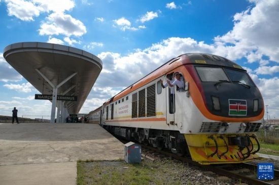 5月31日，在蒙內(nèi)鐵路內(nèi)羅畢站，機車駕駛員蔣立平（右）和博爾在即將開往蒙巴薩的E2次列車上揮手致意。新華社記者 楊光 攝