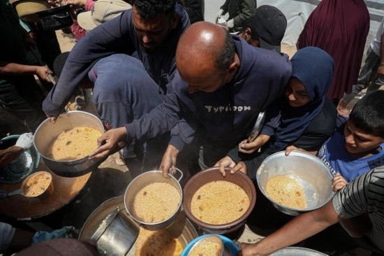 5月28日，人們?cè)诩由吵俏鞑康纳程犭y民營(yíng)領(lǐng)取救助食物。新華社發(fā)（里澤克·阿卜杜勒賈瓦德攝）