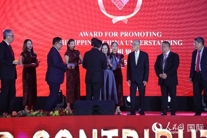 黃溪連大使給榮獲“重要貢獻(xiàn)獎”的奎松市市長喬伊·貝蒙蒂等人頒獎。人民網(wǎng)記者 樊帆攝